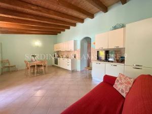 a living room with a red couch and a table at Villa Flavia with pool and private parking in Costa Paradiso