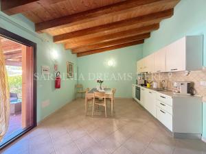a kitchen with a table and a dining room at Villa Flavia with pool and private parking in Costa Paradiso