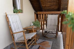 two rocking chairs and a table on a porch at Golden BIS, Subotica in Subotica