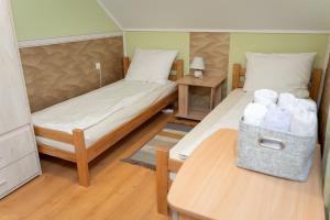 a room with two beds and a table with towels at Golden BIS, Subotica in Subotica