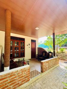 a porch of a house with a brick wall at Sigiri Nisala Resort in Sigiriya