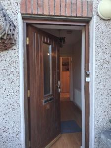 a wooden door leading to a hallway in a building at North Dublin 2-Bed House Sleeps 4 in Dublin