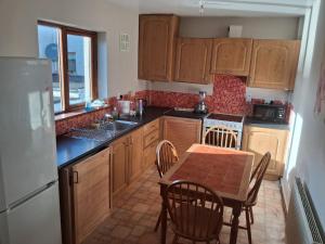 a kitchen with wooden cabinets and a table and chairs at North Dublin 2-Bed House Sleeps 4 in Dublin
