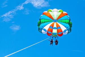 a large colorful parachute flying in the sky at DELUXE OCEAN view VILLAS & Apartments with POOL - PLAYA LOS CORALES, BBQ, SPA in Punta Cana