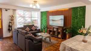 a living room with a couch and a television at WaskarWasi in Cusco