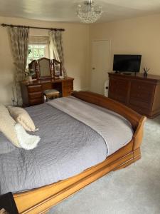 a bedroom with a large bed and a television at West Cottage, Free Breakfast supplied with free range eggs With log burner in Towton