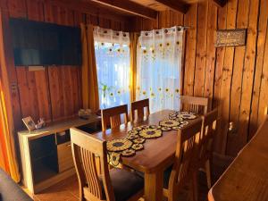 a dining room with a wooden table and chairs at Refugio Barbara Coñaripe in Coñaripe +17 photos