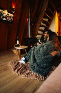 a couple sitting on the floor under a blanket at Cabana Amélia, em Gramado in Gramado