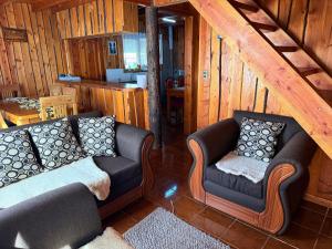a living room with two couches in a cabin at Refugio Barbara Coñaripe in Coñaripe