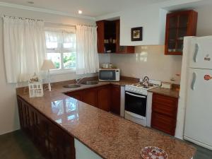 a kitchen with a white refrigerator and a counter top at Casa La Bendición in Mar del Plata