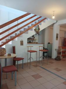 a room with tables and stools under a staircase at Gutza Family in Cumpăna