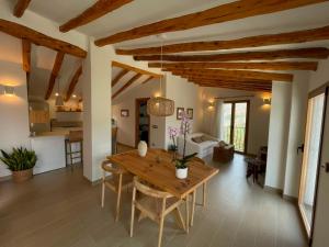 a kitchen and living room with wooden ceilings and a wooden table at El Planet - Apartamento con terraza in Benimantell