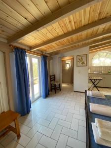a large room with a wooden ceiling and blue curtains at Studio Apartments in Monemvasia