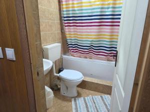 a bathroom with a toilet and a colorful shower curtain at Pensiunea Armand in Supuru de Jos +32 photos
