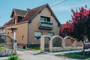 ein Haus mit einem Zaun davor in der Unterkunft Sobe HUBERTUS Lipovac Bajakovo in Lipovac