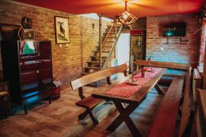 ein Esszimmer mit einem Holztisch und einer Ziegelwand in der Unterkunft Sobe HUBERTUS Lipovac Bajakovo in Lipovac