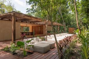 a patio with a bunch of couches on a wooden deck at PenthouseLuxury - Laguna PoolPriv Paddles in Bacalar