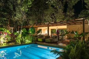 a swimming pool in the middle of a garden at night at PenthouseLuxury - Laguna PoolPriv Paddles in Bacalar