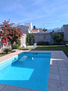a swimming pool with blue water in a yard at Dos Lapachos in San Fernando del Valle de Catamarca
