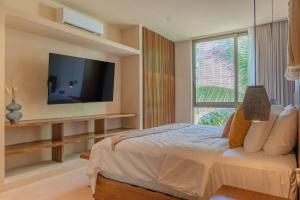 a bedroom with a bed with a tv and a window at PenthouseLuxury - Laguna PoolPriv Paddles in Bacalar +66 photos