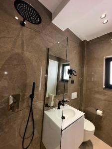 a bathroom with a shower and a toilet and a sink at Hotel Kloi - Rooms & Jacuzzi Vlore in Vlorë