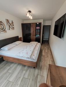 a bedroom with a large bed and a flat screen tv at Casa Mia in Câmpulung Moldovenesc