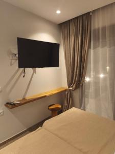a bedroom with a flat screen tv on the wall at Villa Sivo in Kolymbia