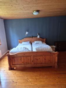 a wooden bed in a bedroom with a blue wall at Klappa in Malmbäck