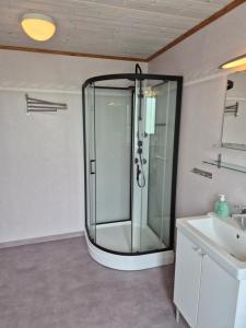 a glass shower in a bathroom with a sink at Klappa in Malmbäck +15 photos