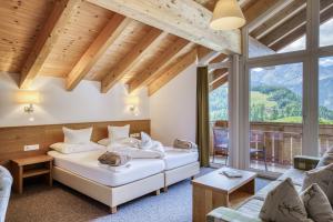 a bedroom with two beds and a living room at Naturhotel Falknerhof in Niederthai