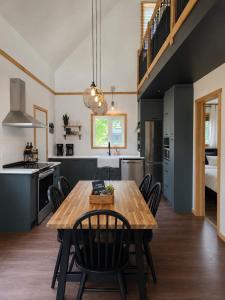 a kitchen and dining room with a wooden table and chairs at Le Lac Apaisant - Rustic Haven by the Water in Saint-Calixte