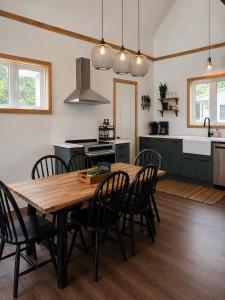 a kitchen and dining room with a wooden table and chairs at Le Lac Apaisant - Rustic Haven by the Water in Saint-Calixte