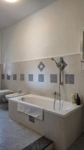 a bathroom with a bath tub and two toilets at La Tana del Ghiro in Condove +31 photos