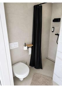 a bathroom with a toilet and a black shower curtain at YourHome 2 in Haigerloch