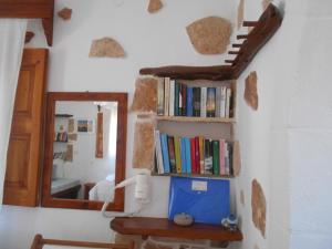 a room with a mirror and a shelf with books at PATMOS Mathios Studios- apartments in Patmos