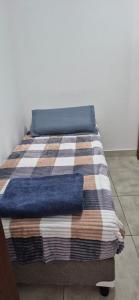 a bed with a colorful blanket on top of it at El hogarcito in Cafayate