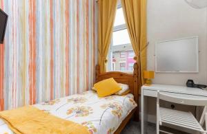 a small bedroom with a bed and a desk at Cherish Lewis Hotel- Hull Road, Blackpool Central in Blackpool