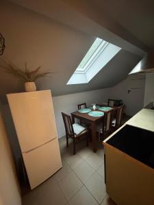 a kitchen with a table with chairs and a skylight at Apartamenty Trzcińsko 47 in Janowice Wielkie +25 photos
