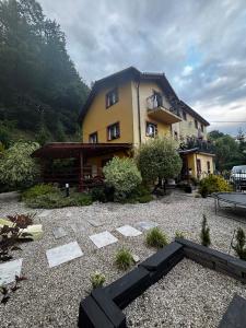 a large house with a gravel yard in front of it at Apartamenty Trzcińsko 47 in Janowice Wielkie