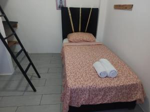 a small bedroom with a bed with two towels on it at Casa Tanger in Tangier
