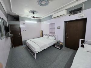 a small room with two beds and a door at Saira Mahal HOTEL in Ajmer