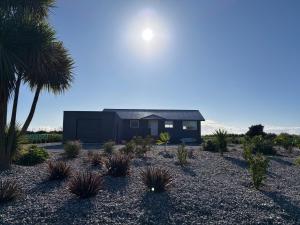 a black house with palm trees in front of it at Carters Beach Escape in Carters Beach