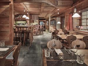 un restaurante con suelo de madera, mesas y sillas en Hotel Schönegg en Wengen