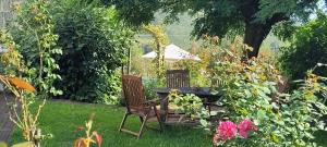 Ein Tisch und Stühle in einem Garten mit Blumen in der Unterkunft Ferienwohnung Raevenhof in Ayl + 2 Fotos