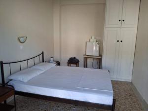 a bedroom with a white bed and a refrigerator at Salamina Sea View in Kakí Vígla
