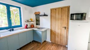 a kitchen with a sink and a wooden door at Entre Bois & Cévennes in Anduze