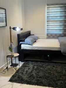 a bedroom with a bed and a lamp and a rug at Parkside City Apts in Accra +10 photos