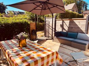 a patio with a table and an umbrella and a couch at O'pOzArt Guesthouse in Durnal