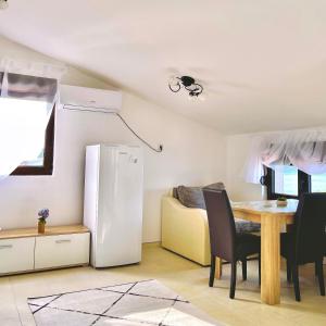 a kitchen and dining room with a table and a refrigerator at Blue Bay Apartments in Krašići