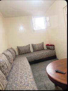 a couch in the corner of a room with a table at Maison traditionnelle cadablabca centre in Casablanca